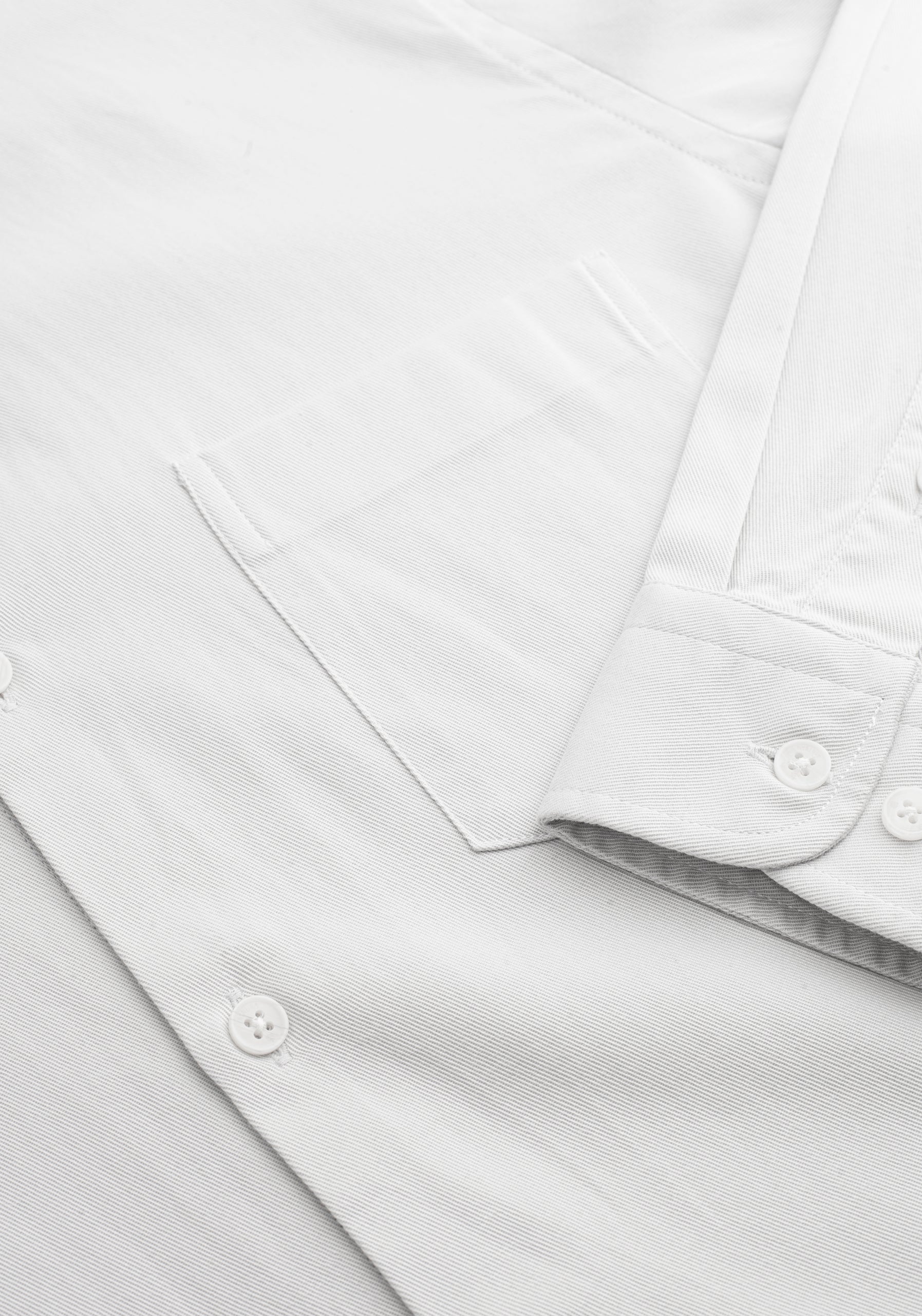 Detalle del bolsillo y botones ocultos de la camisa gris para hombre.